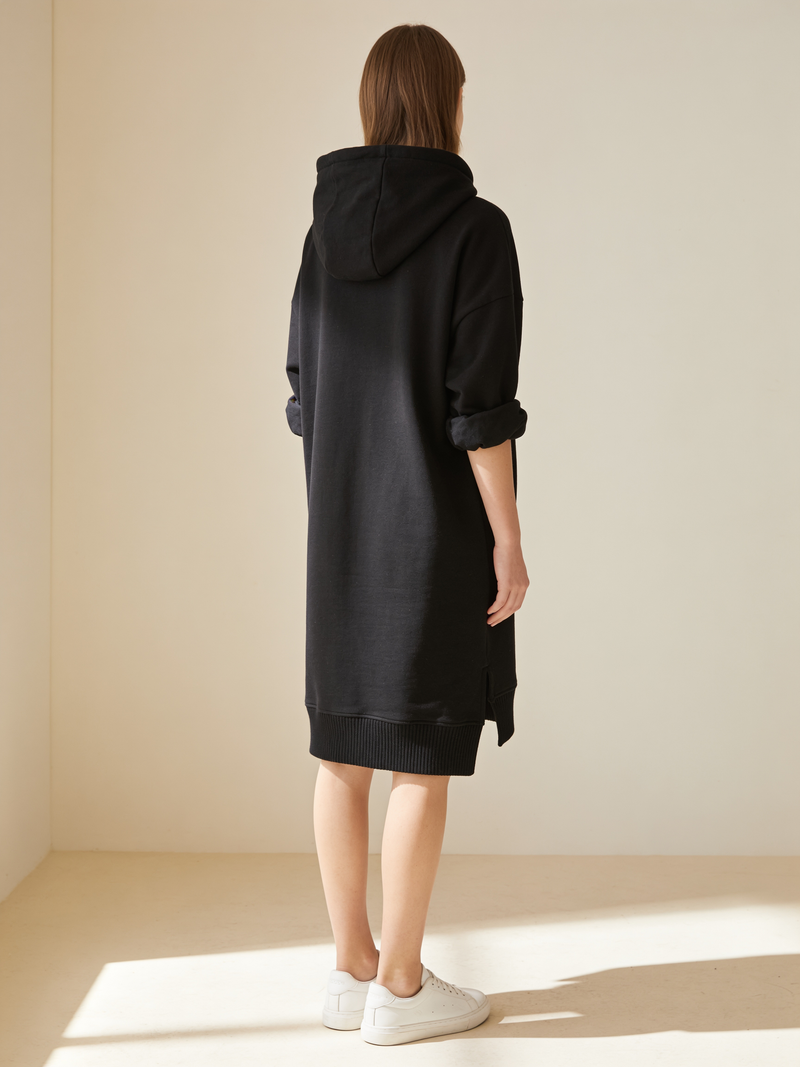 Black hoodie dress back view, hood flat at the shoulders and ribbed hem band